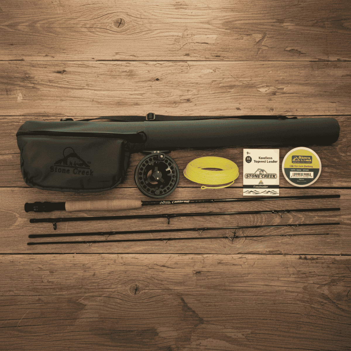 Fly fishing outfit with rod sections, reel, yellow fly line, leader packaging and carrying cases arranged on a wooden surface.