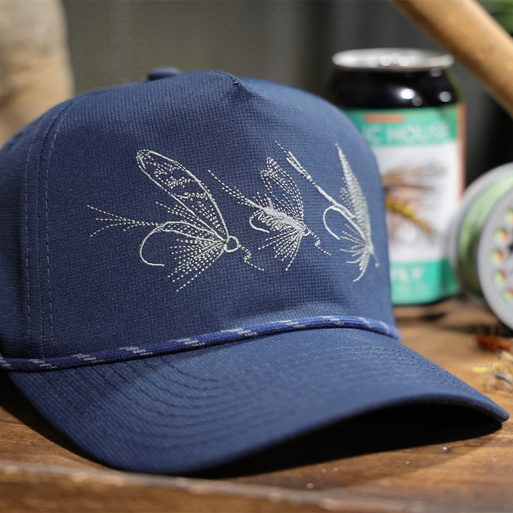 Snap-back trucker hat vintage blue color with 3 artificial flies on the front of hat