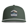 A dark forest green baseball cap with a white stripe along the edge of the brim and a central embroidered patch featuring a mountain landscape and the text 'CLEAR WATER TRADING CO.'.