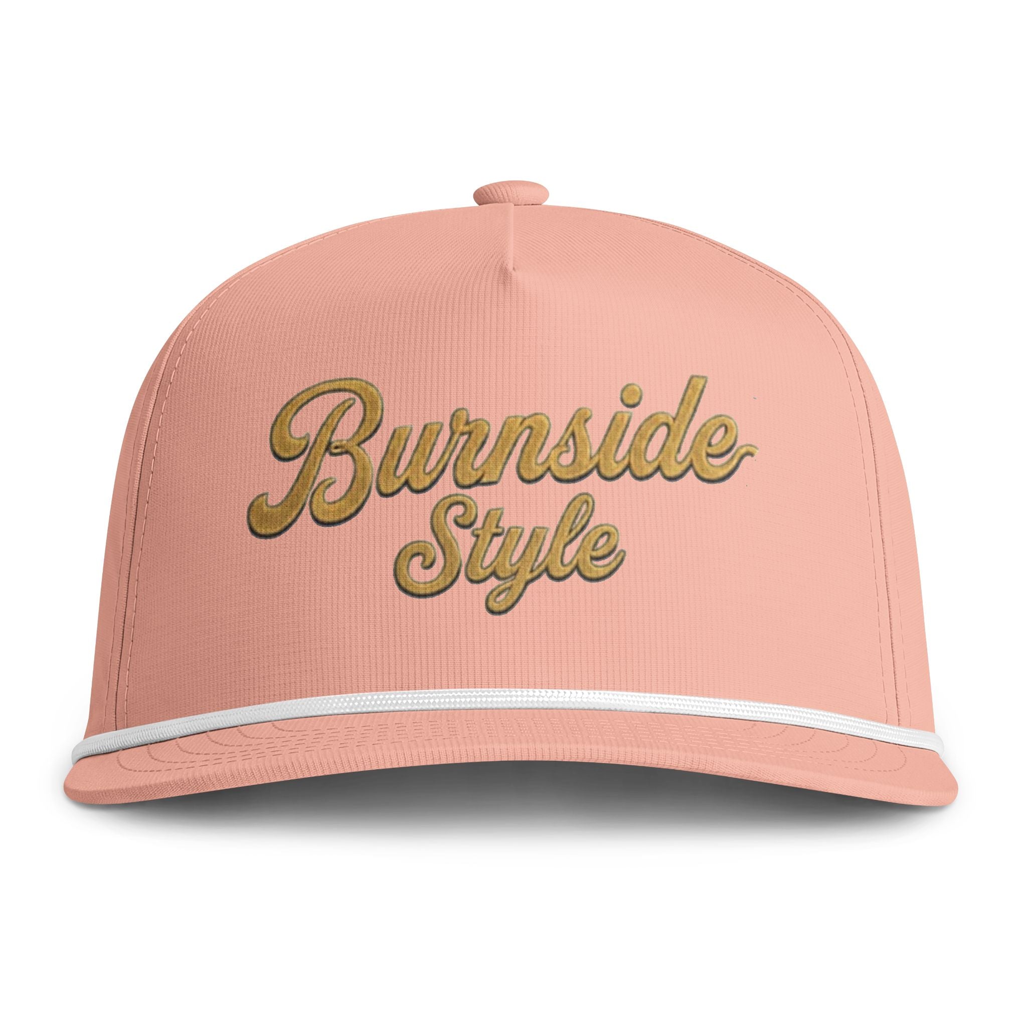 A structured snapback cap in a soft peach-pink color, featuring the words 'Burnside Style' embroidered in a metallic gold cursive font on the front. A thin white stripe accents the edge of the curved brim.