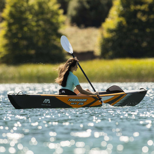Person kayaking on a lake with trees in the background