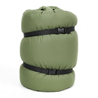 Green sleeping bag with black straps on a white background