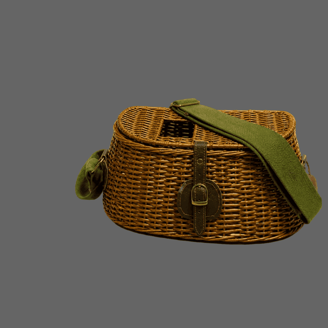 A wicker picnic basket bag with an olive green fabric shoulder strap and a small matching green hanging charm, shown against a solid gray background.